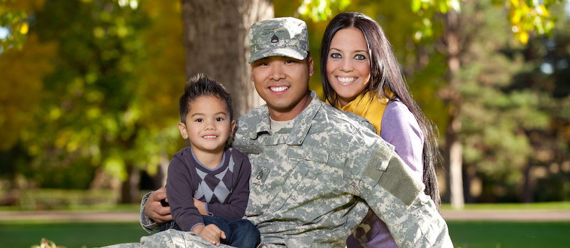 A smiling veteran and his family. For info about the gi bill contact Beal.