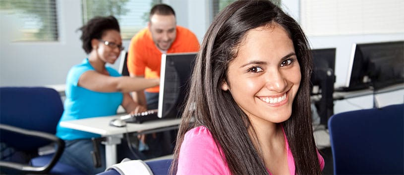 Smiling woman sitting in a computer lab.